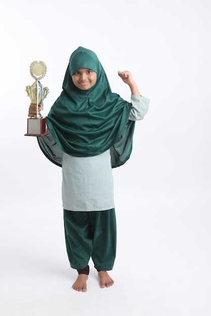 Menina muçulmana indiana com hijab segurando um troféu vencedor