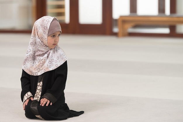 Menina muçulmana rezando na mesquita