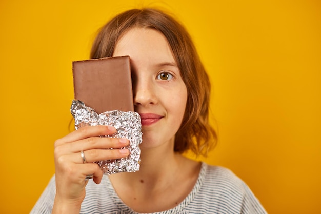 Menina muito adolescente com uma cara de capa de barra de chocolate