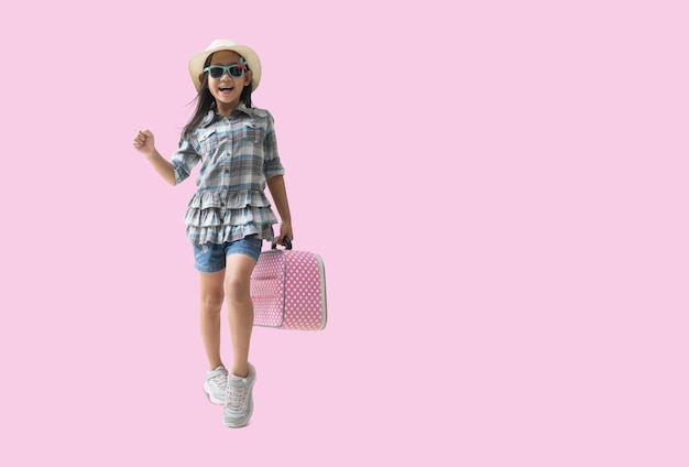 Menina muito asiática e chapéu relaxante conceito de viagem de férias de verão Garotinha bonitinha sorridente isolada em fundo rosa com caminhos de recorte para trabalho de design espaço livre vazio