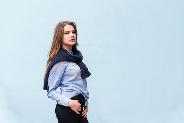 Menina muito bonita em um fundo de parede azul