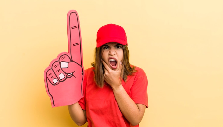 Foto menina muito hispânica com boca e olhos bem abertos e mão no queixo conceito de mão número um