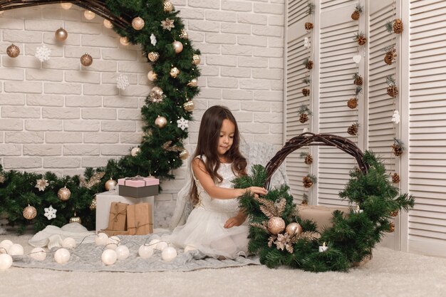 Menina muito sorridente decorando a árvore de Natal em casa