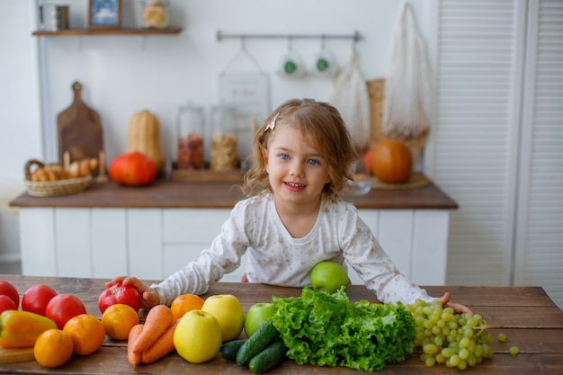 menina na cozinha com sorrisos de vegetais