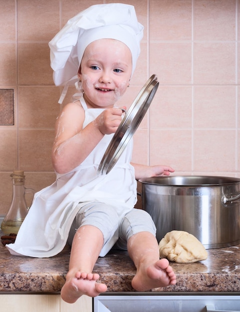 menina na fantasia de cozinheiro