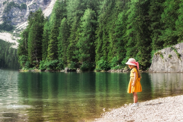 Menina na margem de um belo lago