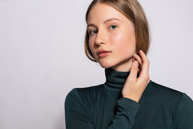 Menina na moda linda hippie. Foto de uma jovem simpática positiva em meias verdes até o joelho com fundo branco. olha para a câmera.