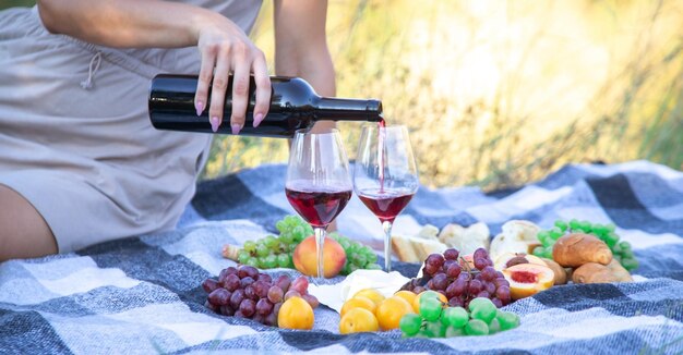 Menina na natureza bebe vinho. Foco seletivo