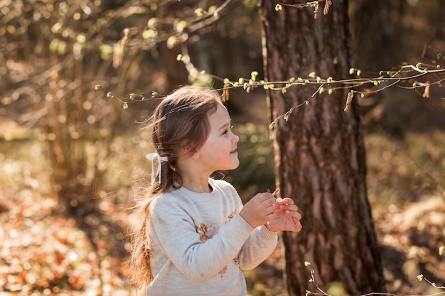 menina na natureza examina plantas