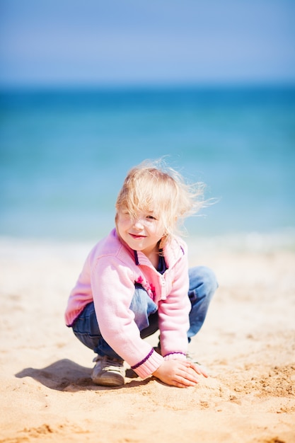 Menina na praia de areia