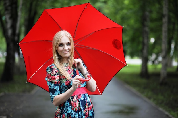Menina na rua com um guarda-chuva para passear num dia de verão