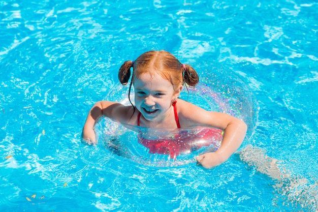 Menina nadando na piscina no verão