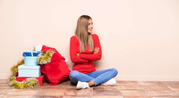 Menina nas férias de Natal, sentada no chão rindo