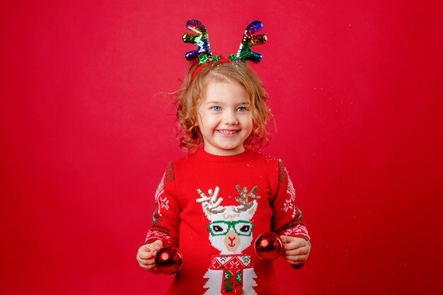 Menina natal cervo chifres fundo vermelho, ano novo.