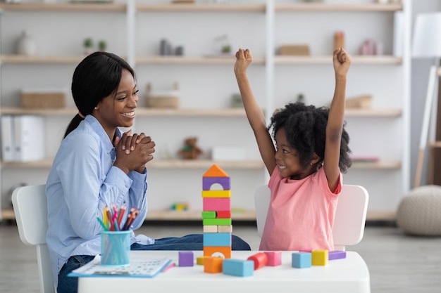 Menina negra inteligente tendo sessão com especialista em desenvolvimento infantil