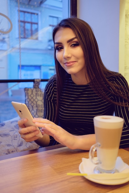 Menina no café com smartphone