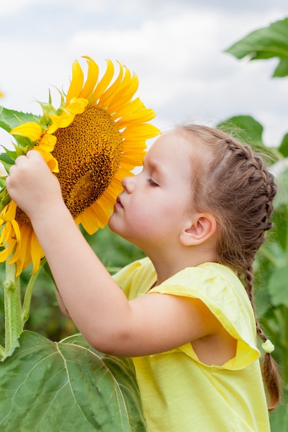 Foto menina no campo com girassóis. natureza