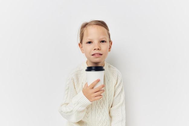 Menina no copo de suéter branco com fundo claro de bebida