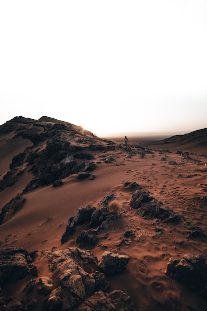 Foto menina no deserto ao nascer do sol