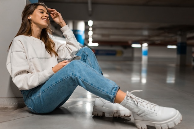 Menina no estacionamento subterrâneo ouvindo música