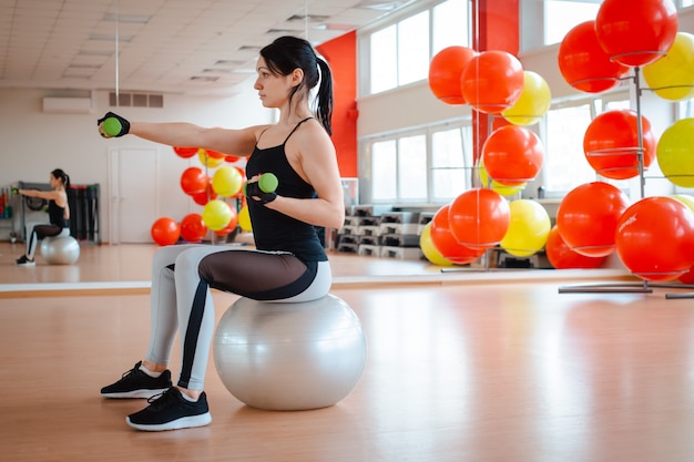 Menina no ginásio fazendo exercícios de fitness.