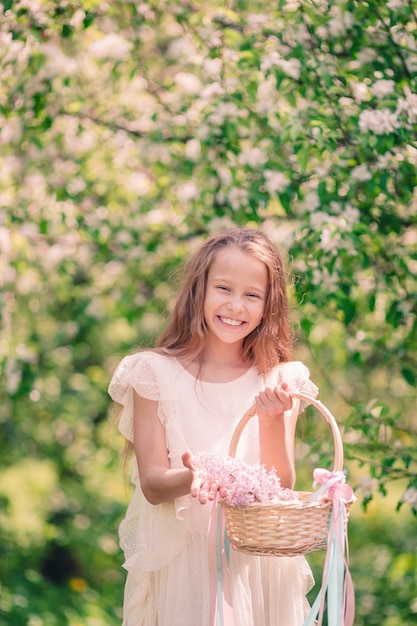 Menina no jardim de maçã florescendo no lindo dia de primavera