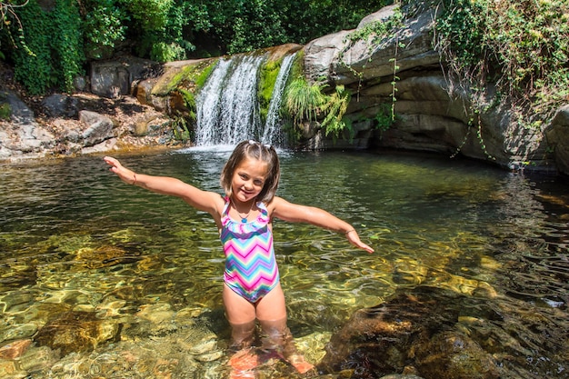 Menina no meio da natureza com uma paisagem espetacular com riachos de água cristalina