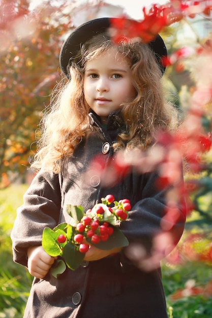 menina no parque com um ramo de frutas vermelhas