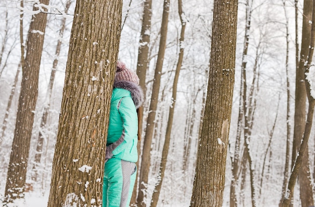 Menina no parque de inverno nevado. Conceito de neve, frio e sazonal