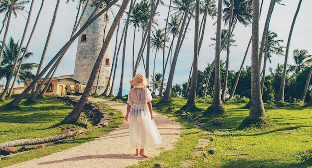 Menina no Sri Lanka em uma ilha com um farol