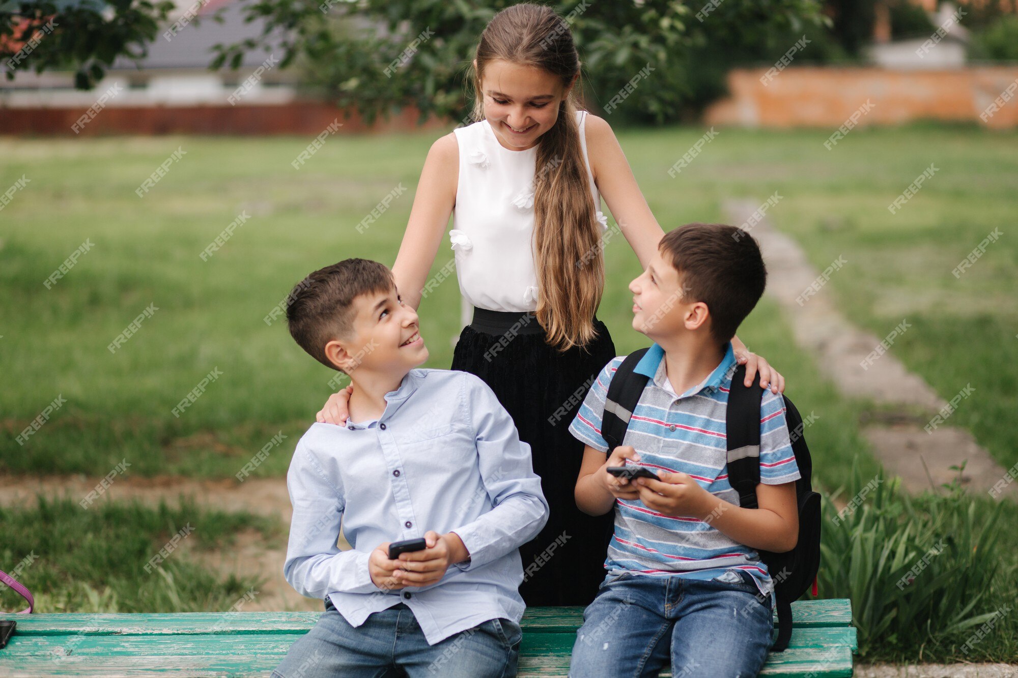 Menina olha como o menino joga o jogo online. dois meninos jogam jogos  online em quarentena. rapazes sorriem e