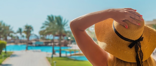 Menina olha para a piscina e o mar.