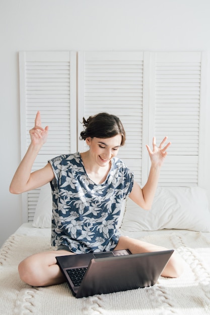 Menina olhando o laptop na cama