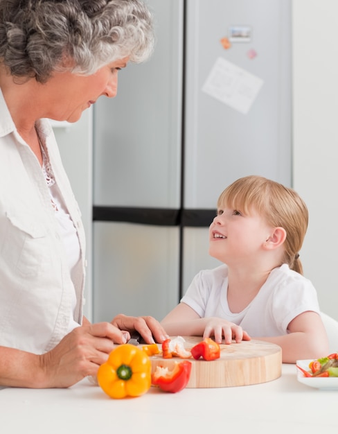 Foto menina olhando para a avó que está cozinhando