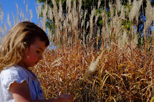 Foto menina olhando para a grama