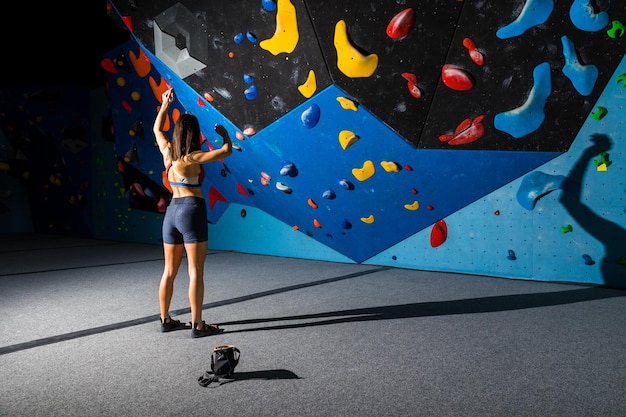 Menina olhando para uma parede de escalada