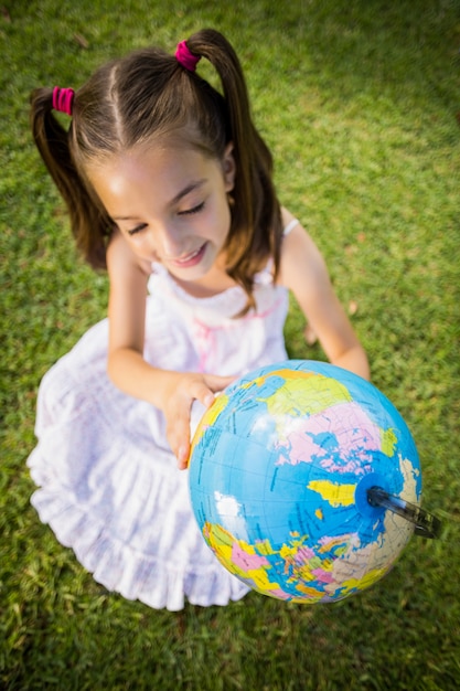 Foto menina olhando um globo