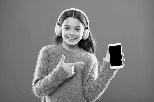 Menina ouça música em fones de ouvido modernos e smartphone Ouça gratuitamente Obtenha assinatura familiar de música Acesso a milhões de músicas Desfrute do conceito de música Melhores aplicativos de música que merecem uma audição