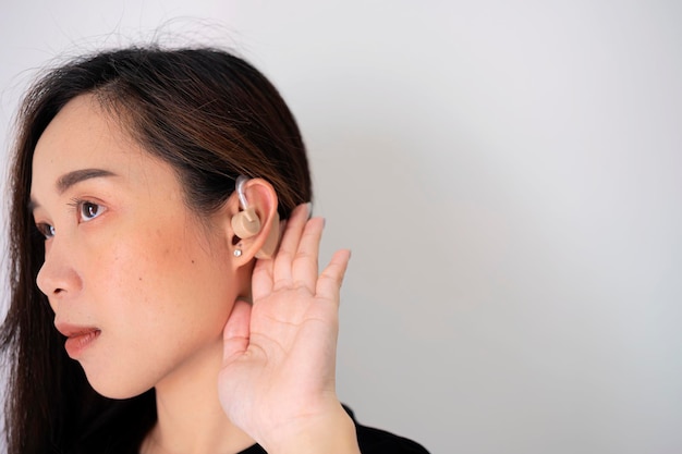 Menina ouvindo com a mão em um teste de audição mostrando ouvido de jovem