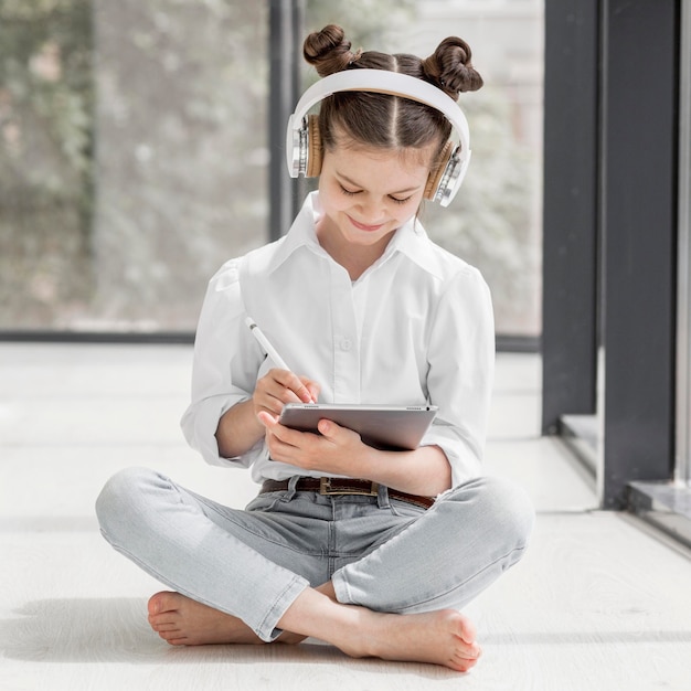 Foto menina ouvindo seu professor através de fones de ouvido