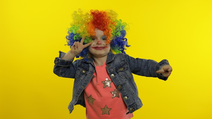 Foto menina palhaçada com peruca colorida fazendo caras bobas divertindo-se sorrindo dançando halloween