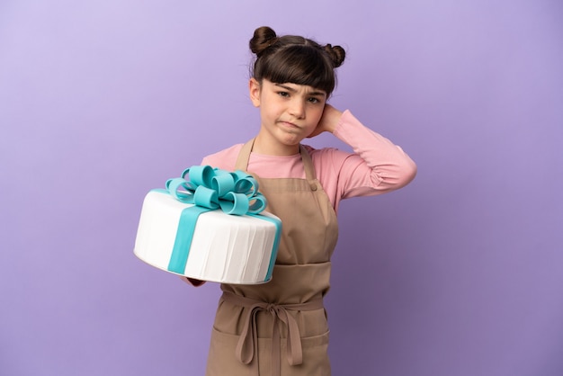 Menina pastelaria segurando um grande bolo isolado na parede roxa, tendo dúvidas