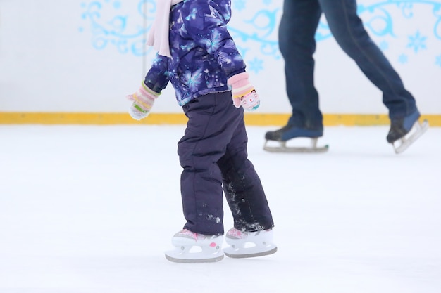 Menina patinando na pista de gelo