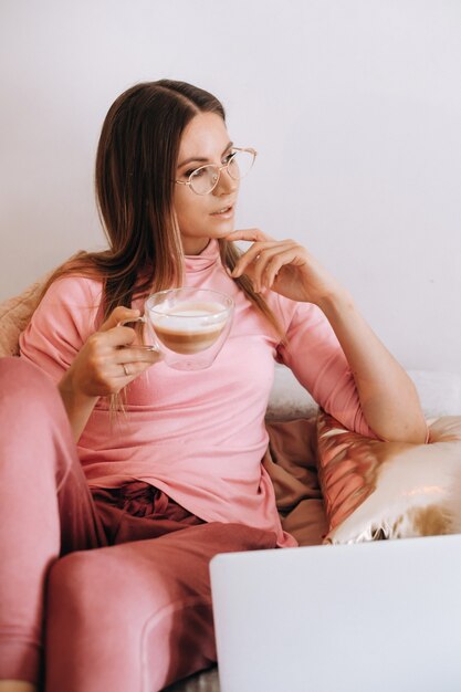 Menina pela manhã de pijama em casa tomando café