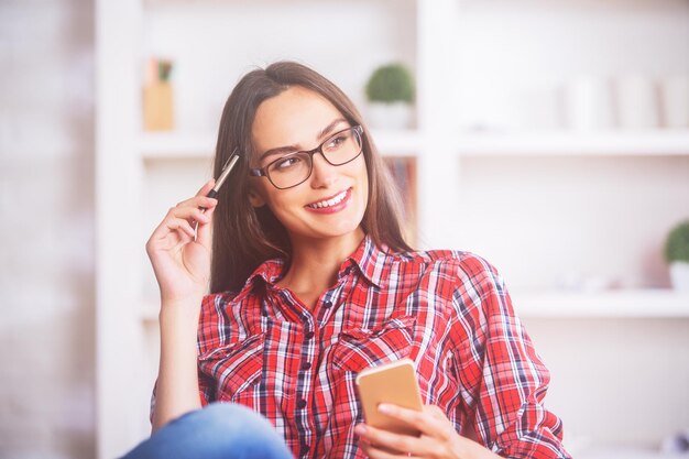 Menina pensativa usando celular