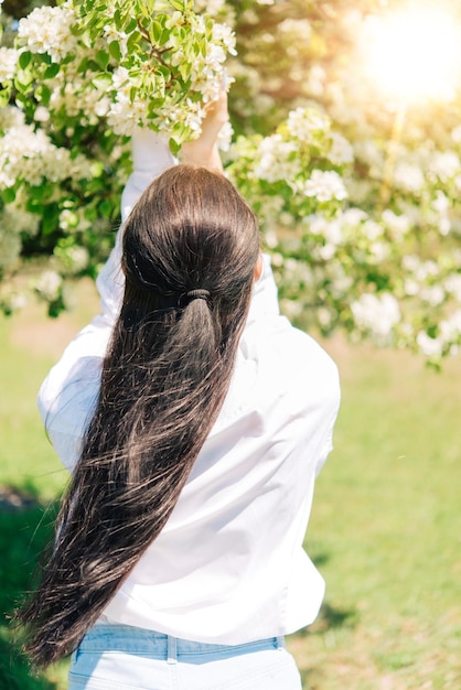 Menina perto de uma árvore florida. foto romântica de primavera. árvore florescendo.