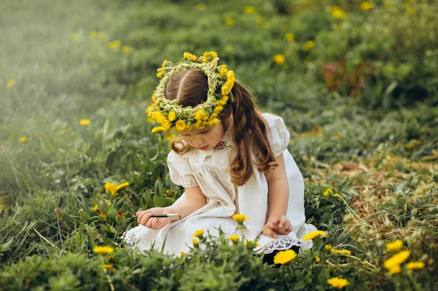 menina pinta um pincel de flores amarelas no campo