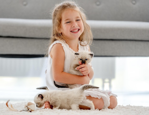 Menina pintando com gatinhos bonecos de pano