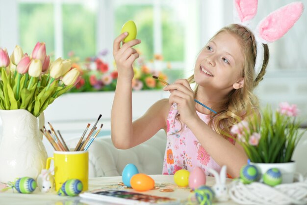 Menina pintando ovos para o feriado de Páscoa