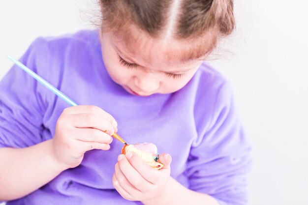 Menina pintando sobre tela com tinta arcílica.